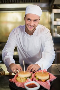 Male chef preparing burger in commercial kitchen