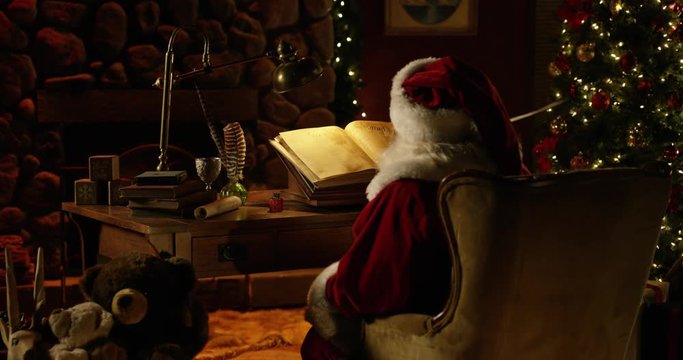 Zoom in on Santa adjusting Naughty/Nice List with quill in North Pole