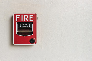 red fire alarm box on white concrete background. over light