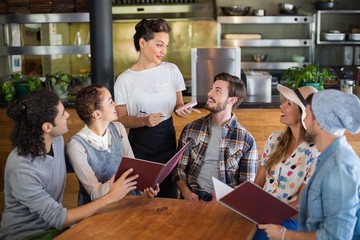 Waitress talking to customers in restaurant