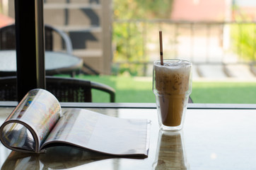 Iced coffee in a tall glass on wooden background