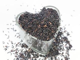 Fototapeta premium Rice-berry in heart shape glasses on white background