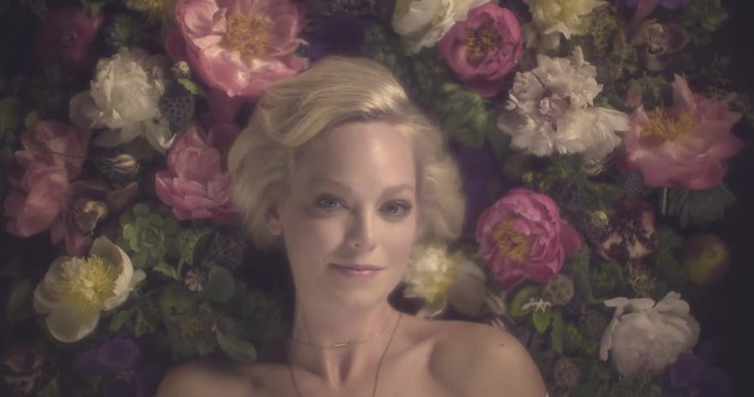 Beautiful woman lies in bed of flowers