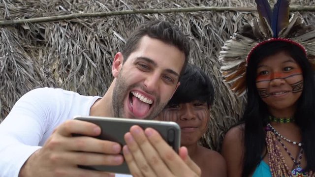 Tourist taking a selfie photos with Brazilian Natives - Indios