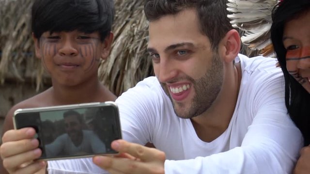 Tourist taking a selfie photos with Brazilian Natives - Indios