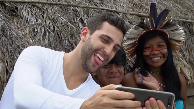 Tourist taking a selfie photos with Brazilian Natives - Indios