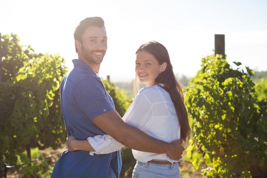 Portrait of smiling couple embracing at vineyard