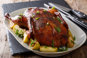 Festive baked duck with apples close-up on a table. horizontal