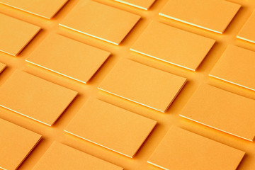 Mockup of horizontal golden business cards stacks arranged in rows at textured paper background.