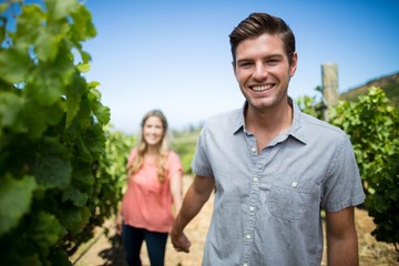 Obraz premium Happy young man holding woman hand at vineyard