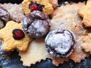 Festive cookies on a black kitchen board with powdered sugar