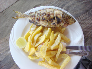 chipsy samaki chips with fried fish and salt on white dish