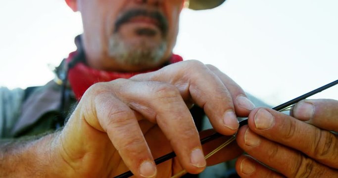 Fly fisherman putting new string on fishing rod