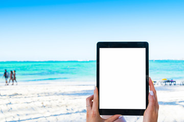 Blank empty tablet computer in the hands of girl on the beach