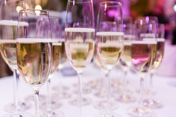 a row of glasses filled with champagne are lined up ready to be served