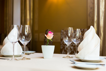 Pink rose in a vase as table decoration. Table setting