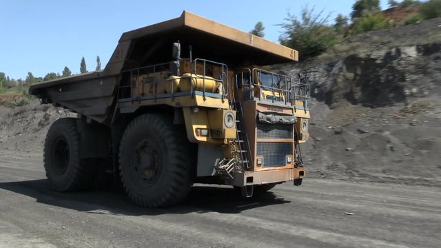 heavy dump trucks maneuver in iron ore quarry