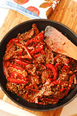 Spicy veal and vegetable stew in black pan on wooden board