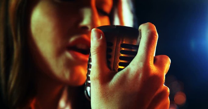 Close-up of female singer singing in studio