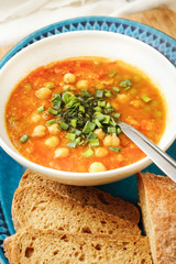 Soup of carrots and corn with bread in white bowl