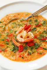 Hearty tomato soup with prawns in white platter