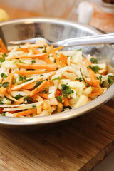 Kohlrabi and carrot salad with apple  ginger sauce on wooden board