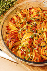 Baked crispy fries with herbs in glass bowl