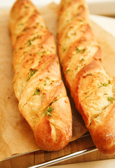 French style bread with wrapped paper on wooden board
