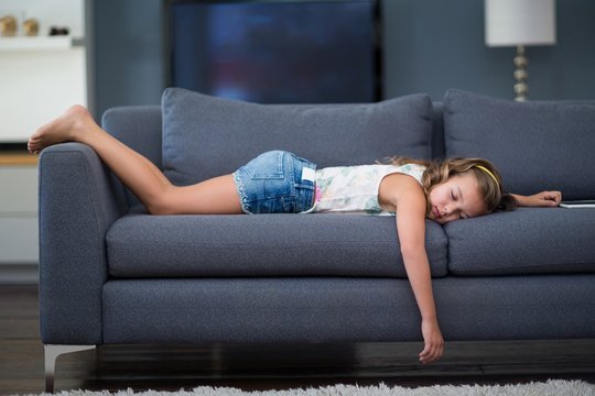 Girl sleeping on sofa in living room