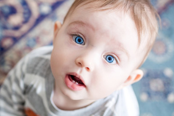 closeup of beautiful happy baby with blue eyes looking up
