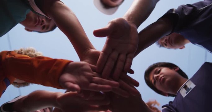 Young athletes put their hands in for a cheer one-by-one.