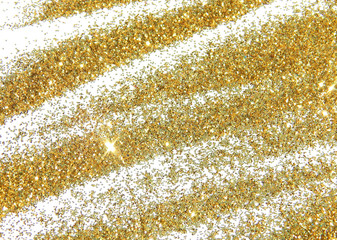 Golden glitter sparkles on white background. 