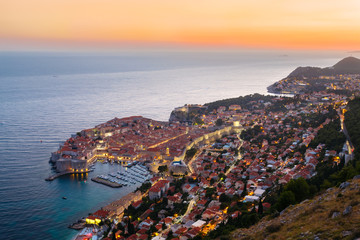 A view from above of Dubrovnik with the old part of the city during a bright colorful sunset.