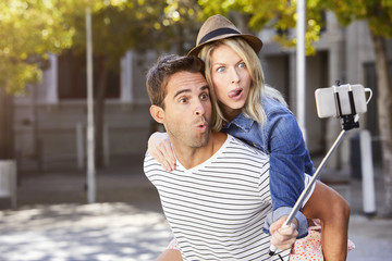 Couple messing about for selfie in city