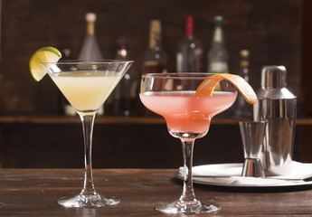 Two alcohol cocktail glasses on the bar.