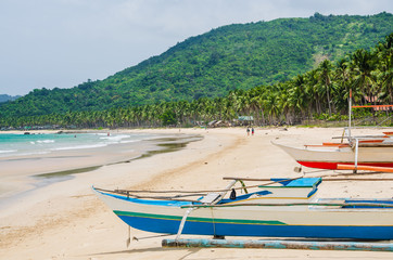 Fototapeta na wymiar Local boats on Nacpan Beach on sunny day. El Nido, Palawan, Philippines
