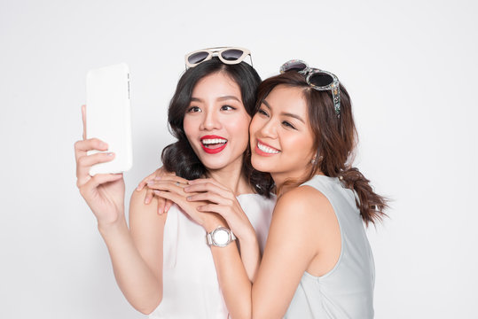 Portrait Of Two Beautiful Asian Fashionable Women Taking Selfie