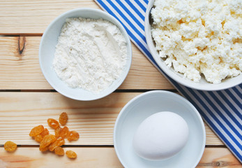 Making of russian style breakfast syrniki or cottage cheese pancakes ingredients on wooden table.