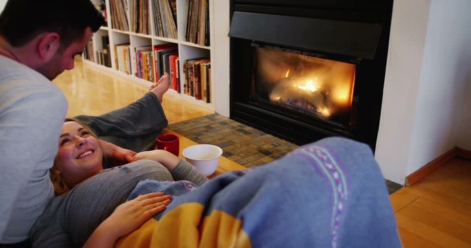 Couple relaxing near fireplace in living room