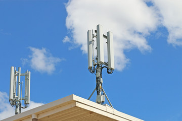 telephone exchange with cellular antennas on roof against blue sky