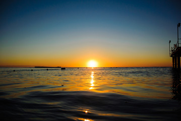 Fototapeta na wymiar Colourful sea sunrise in soft waves 