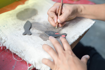 This woman is decorating the pottery