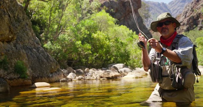 Fisherman fly fishing in river