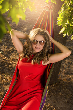Woman in red dress lying in hammock