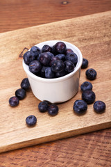 Pot of blueberries on a rustic background