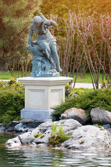 Fountain with statue of a woman in the park near the lake