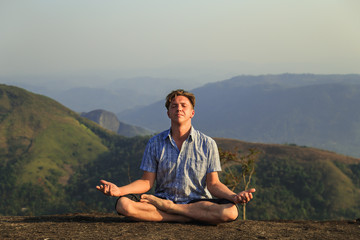 Man is engaged in physical exercises among the mountains.