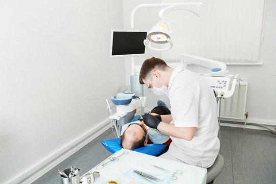 Dentist doctor treats the teeth to the patient