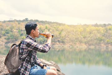 Happy Asian hipster man backpack in nature background, Relax time on holiday concept travel , color of vintage tone and soft focus