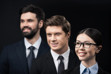 group of smiling business people standing in row isolated on black